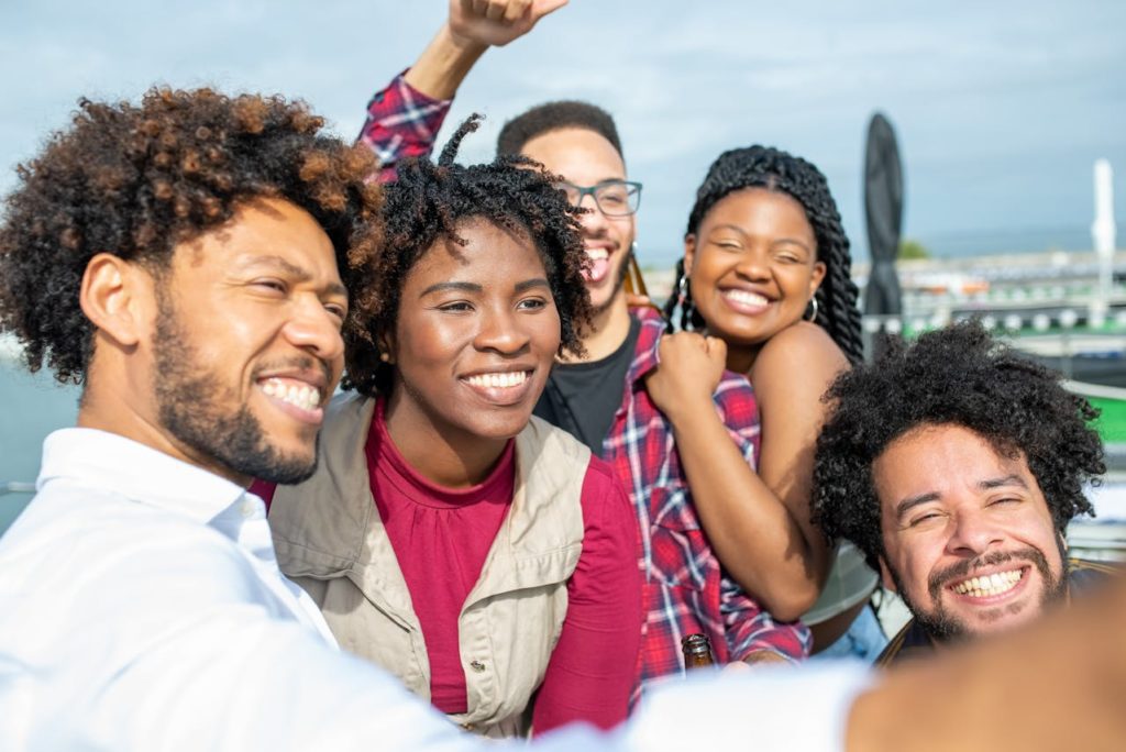 Junge Menschen auf einem Grillfloß in Berlin lachen in die Kamera